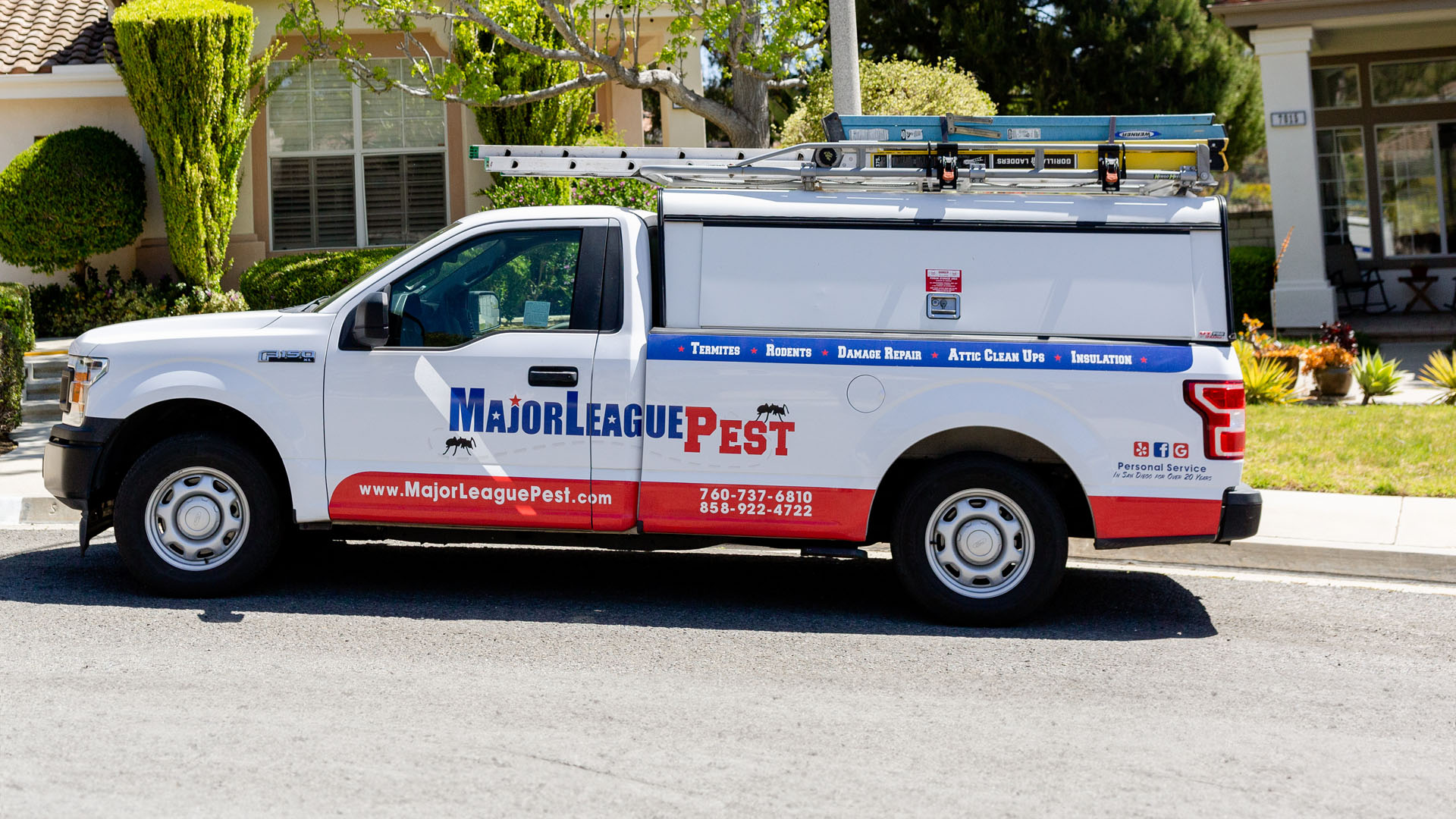 White and red pest control service truck labeled "Major League Pest" parked in front of a residential home, equipped with a ladder and tools on top.